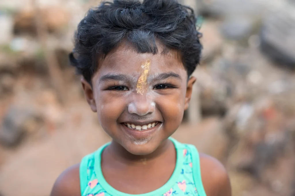 young smiling girl yellow paint on her face